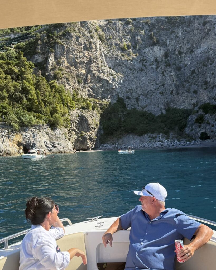 Coppia in barca davanti a una cala