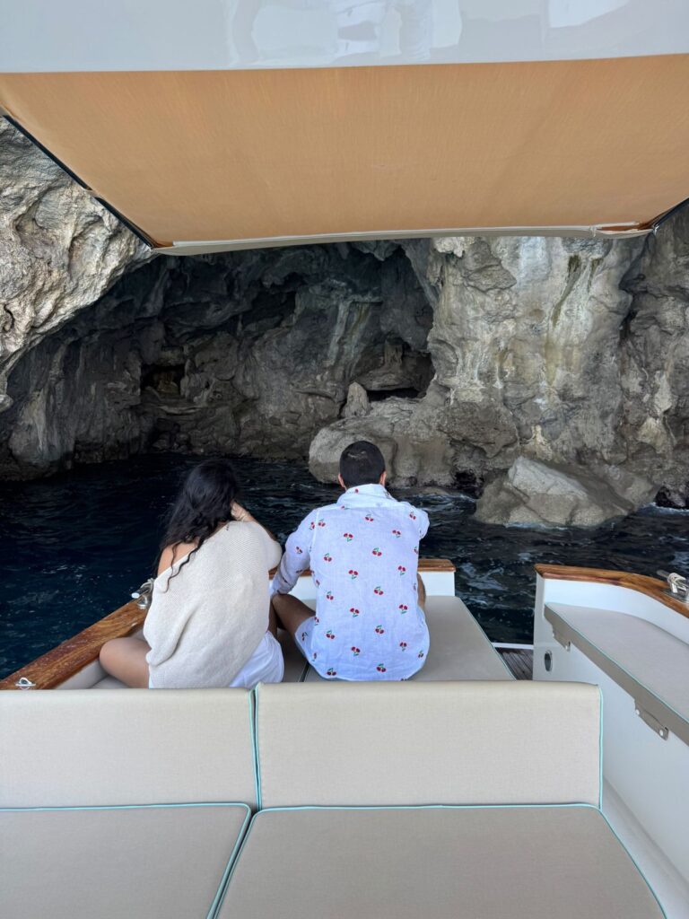 Couple exploring a sea cave by boat